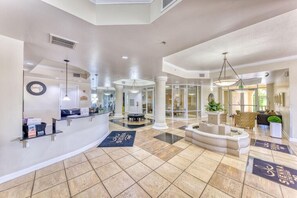 Experience the welcoming atmosphere of our lobby, featuring a central seating area, pendant lights, and a reception desk.