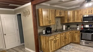 Una cocina con armarios de madera, estufa de acero inoxidable y encimera de granito.