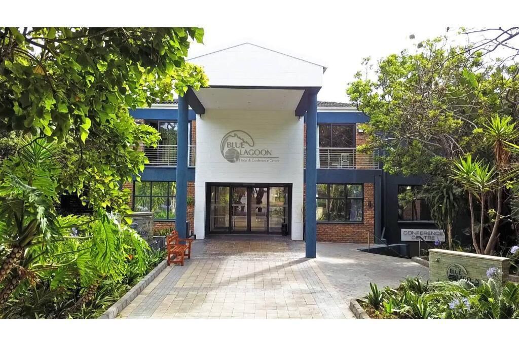 A building with a sign reading "BLUE LAGOON Hotel & Conference Centre" and a covered entrance.