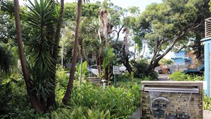 A lush garden with a water feature and a sign for 'Blue Lagoon Hotel & Spa Centre'. - Blue Lagoon Hotel and Conference Centre (East London)