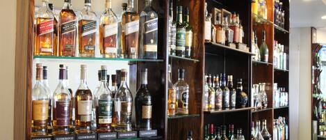 A bar with shelves stocked with various liquor bottles.