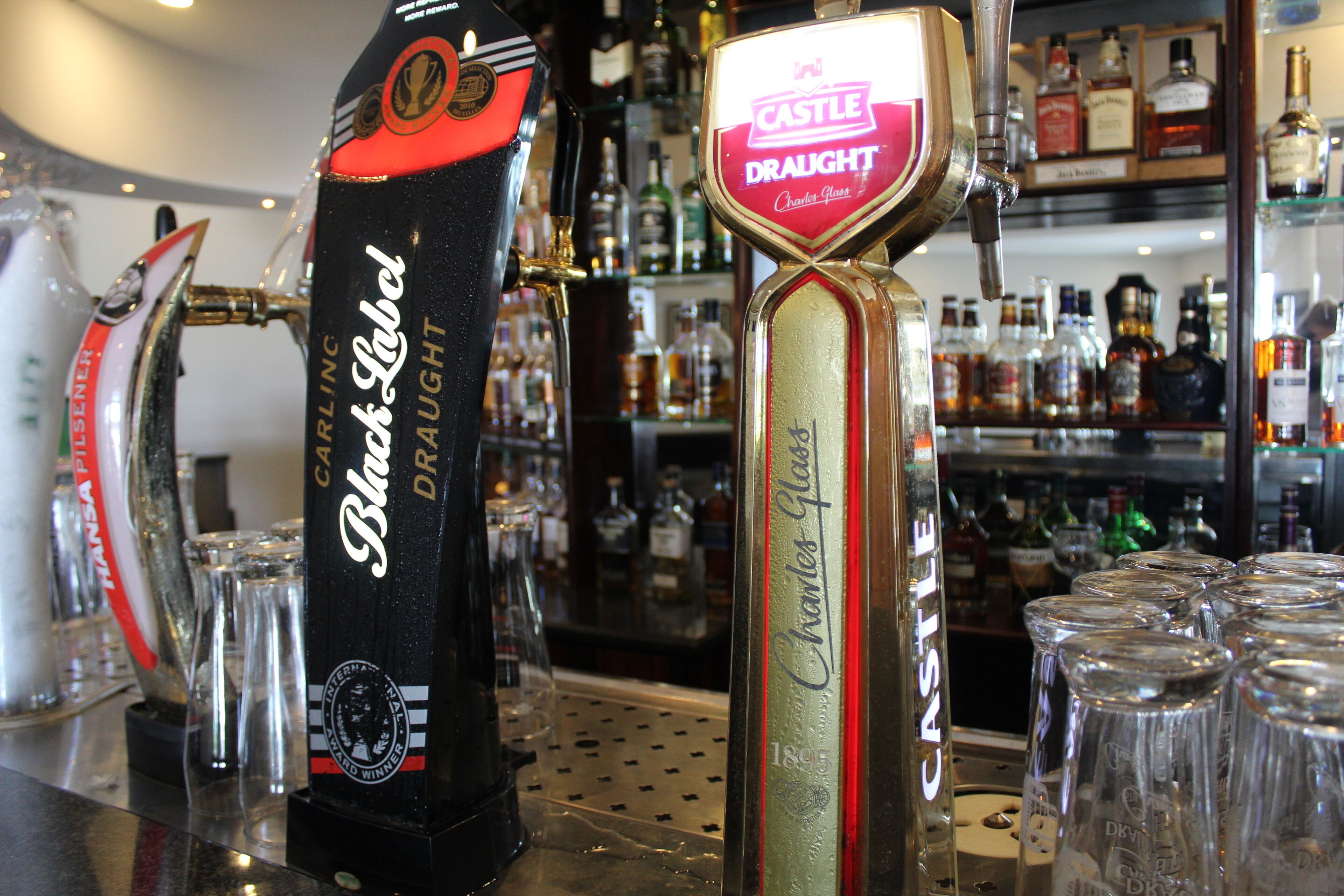 A bar with two beer taps labeled 'Castle Draught' and 'Black Label'.