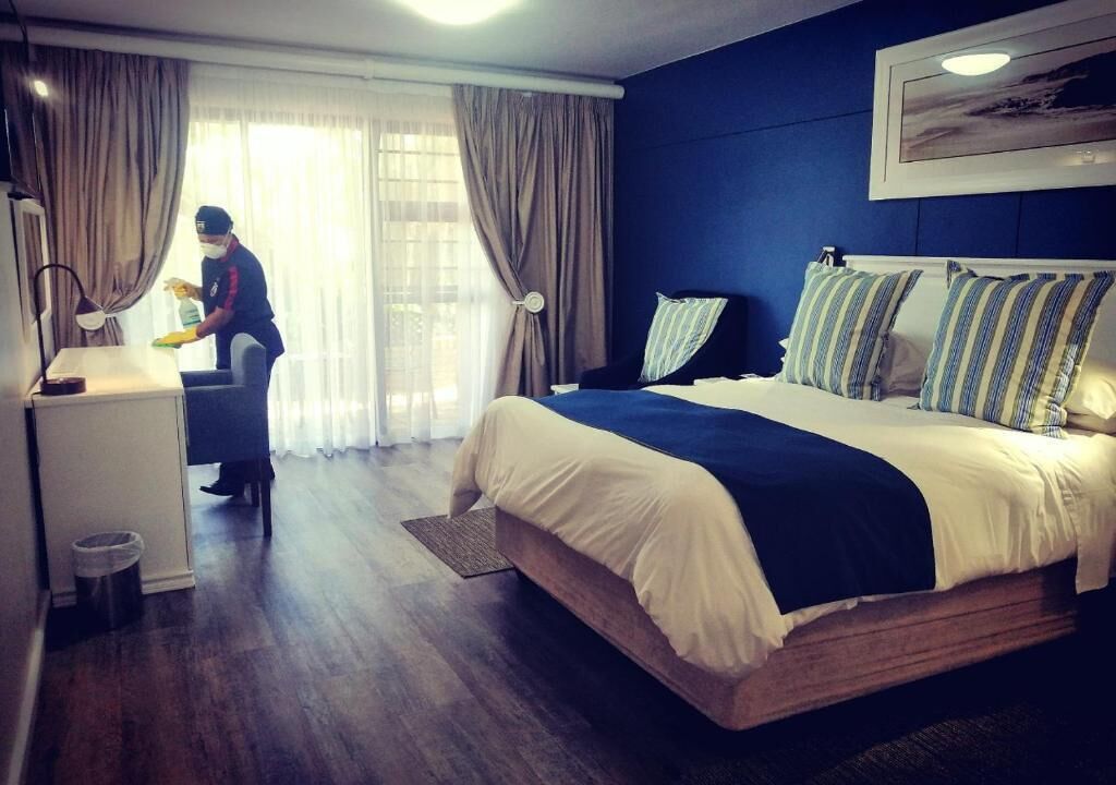 A hotel room with a bed, a desk, and a chair.