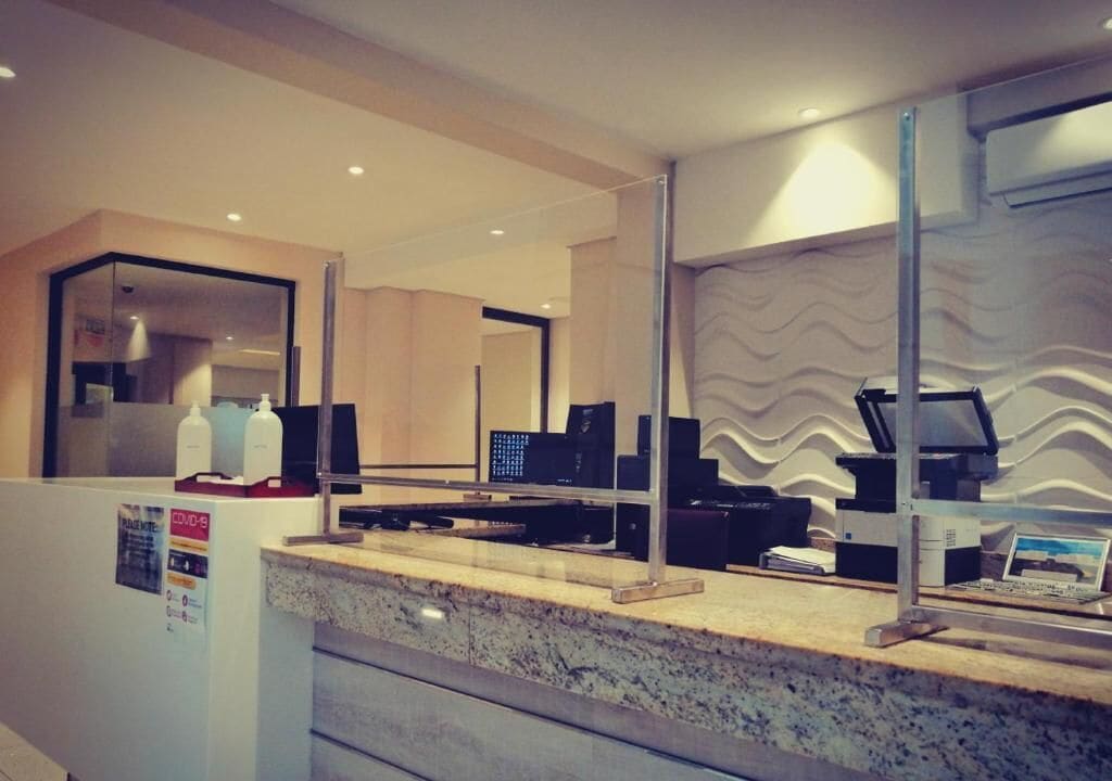 A reception area with a marble counter, computer monitors, and a wall-mounted printer.