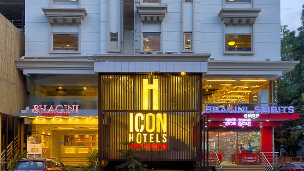 Un hotel de varios pisos con un letrero destacado para "BHAGINI ICON HOTELS" y "BHAGINI SPIRITS".