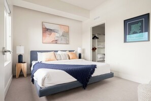Een slaapkamer met een bed, een nachtkastje, een wandlamp, een kast en een lijst met een kaart van Denver.