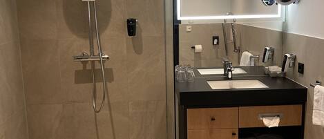 A modern bathroom with a shower, a sink, and a toilet.