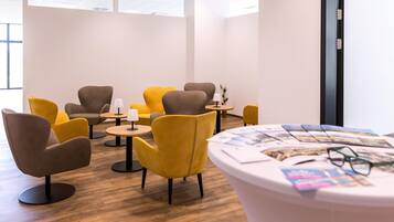 A modern lounge area with comfortable seating and a reception desk.