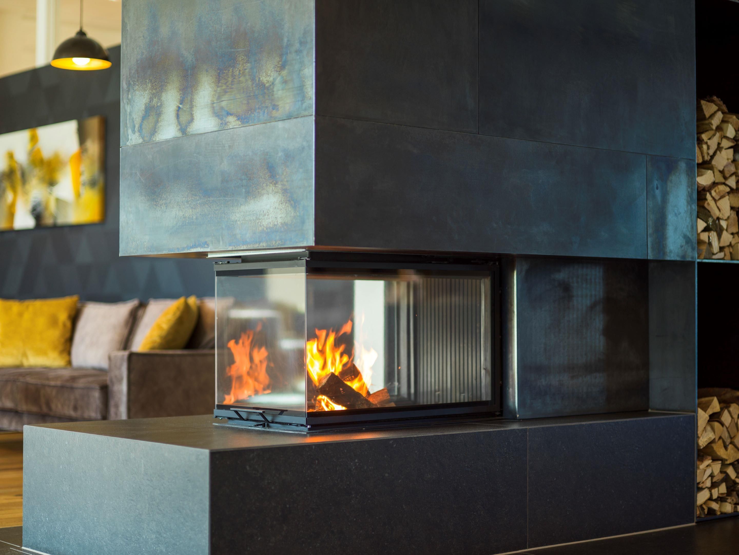 A modern fireplace with a glass front, a dark-toned mantel, and a log storage area to the right.