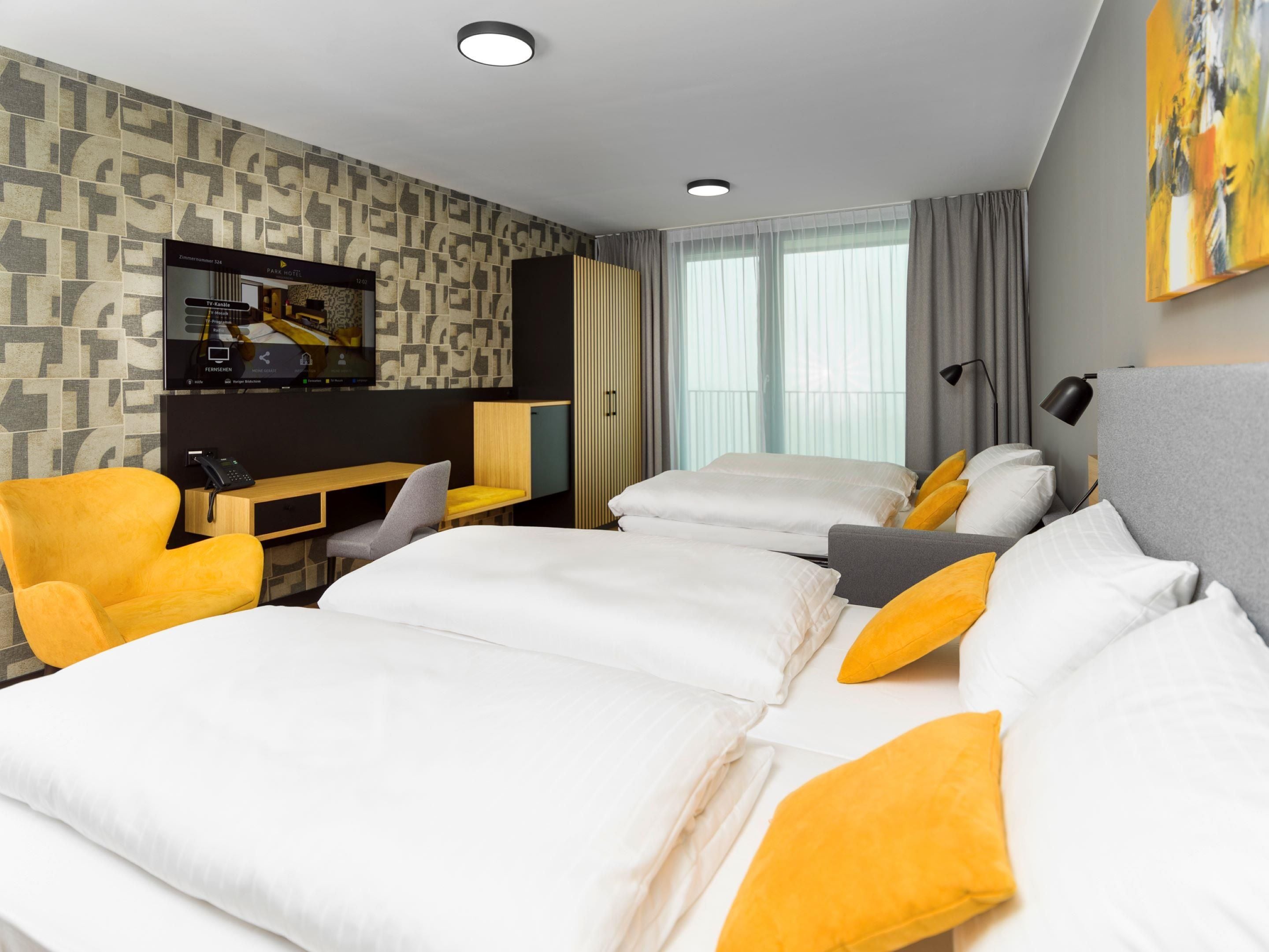 Een hotelkamer met een groot bed, een bureau en een televisie.
