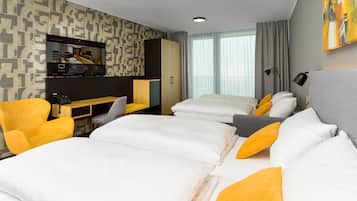 A hotel room with a large bed, a desk, and a TV.