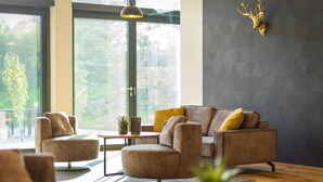 A modern living room with a sofa, armchairs, a coffee table, and a decorative deer head on the wall. - Best Western Parkhotel Hagenberg (Hagenberg im Mühlkreis)