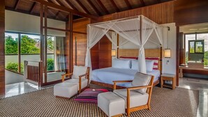Un dormitorio amplio con una cama grande, dosel y vistas al verdor exterior.