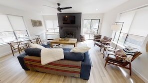Amplia sala de estar con chimenea, un sofá, una mesa de centro y un televisor.