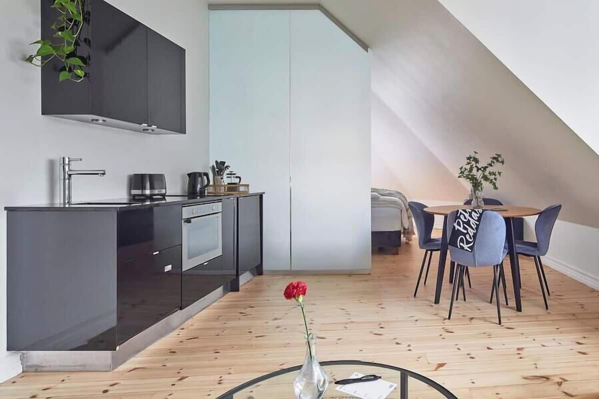 Eine moderne Küche mit Essbereich, einem kleinen Tisch mit Stühlen und einem Wohnbereich mit einer Couch.