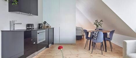 Una cucina moderna con zona pranzo, un tavolino con sedie e un angolo relax con divano.