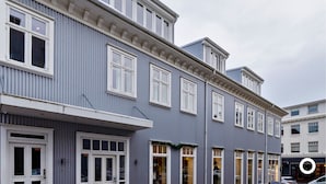 A row of traditional buildings with white-framed windows and a grey facade.