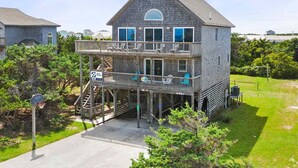 A two-story house with a balcony, a visible staircase, and a basketball hoop. - Semi-Oceanfront Dog Friendly w/ Saltwater Pool, Hot Tub, Game Room, Volleyball (Avon)