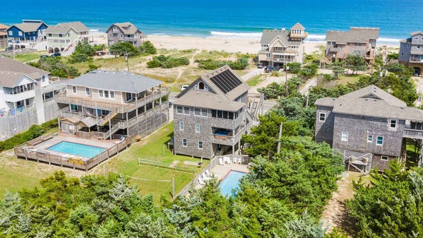 A coastal residential area with houses, a swimming pool, and a beach view. - Semi-Oceanfront Dog Friendly w/ Saltwater Pool, Hot Tub, Game Room, Volleyball (Avon)