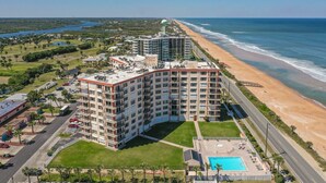 A high-rise hotel with multiple floors, a swimming pool, and a beach view. - Direct Beach Views - Sleeps 4, Corner Unit Tennis - Pool (Flagler Beach)
