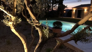 A pool surrounded by trees and a building with illuminated windows. - 3 minutes from the center (Provencal village) and shops: Mas St Olive with swimming pool (Maussane-les-Alpilles)