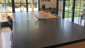A modern kitchen with a large island, wooden cabinets, and a view of the garden through large windows. - 3 minutes from the center (Provencal village) and shops: Mas St Olive with swimming pool (Maussane-les-Alpilles)