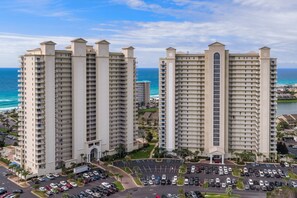 Deux grands hôtels avec des balcons, un parking et une vue sur l’océan.
