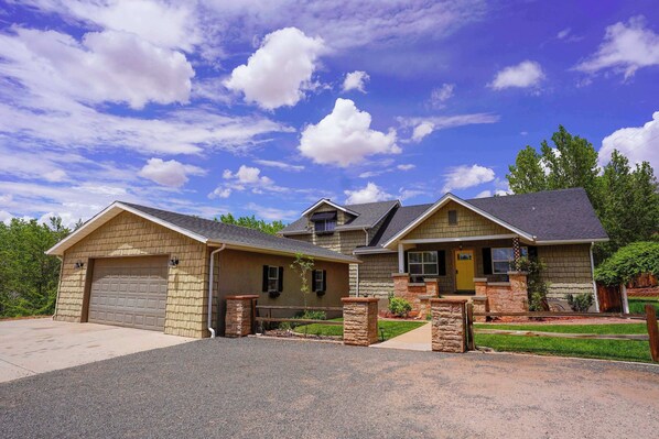 A two-story house with a garage, a front porch, and a well-maintained lawn. - Spacious Retreat w/ Views Near Zion & Bryce UT (Kanab)