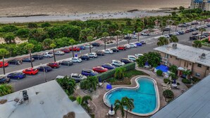 Ein Hotel mit Swimmingpool, Parkplatz und Blick auf den Strand.