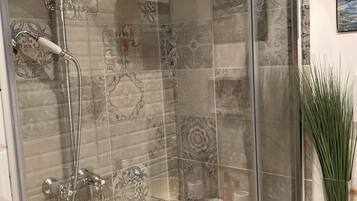 Regadera, tina de hidromasaje, secadora de cabello, toallas