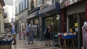 Una strada con negozi e una bancarella di libri.