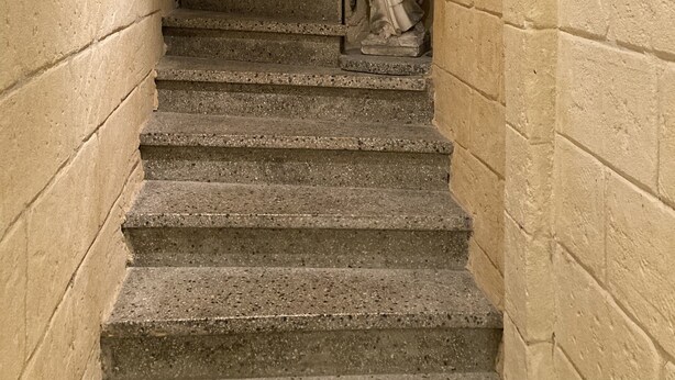 Una scala in pietra con una statua in cima.