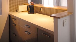A kitchen with a tiled backsplash, a toaster, a coffee maker, and a mirror above the counter. - ★ Zen cocoon, calm & bright in Belleville ★ (Paris)