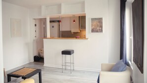 A modern living room with a kitchen area, a dining table, and a bar stool. - ★ Zen cocoon, calm & bright in Belleville ★ (Paris)