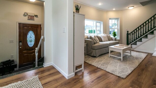 A living room with a sofa, coffee table, and a staircase.
