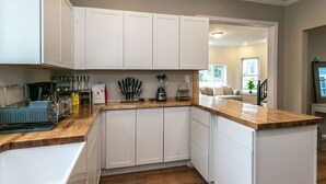 A kitchen with white cabinets, a wooden countertop, and a built-in island.