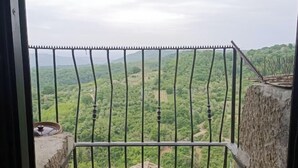 A balcony with a metal railing overlooking a lush green landscape. - La Casetta in the historic center of Bomarzo (Bomarzo)