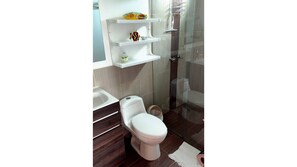 Bathroom features a toilet, walk-in shower, and storage shelves.
