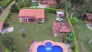 A large house with a swimming pool, a covered patio, and a well-maintained garden. - Ideal chalet: tourism in the coffee region with swimming pool. (Ulloa)