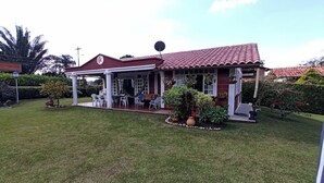 A house with a covered patio, a small garden, and a satellite dish. - Ideal chalet: tourism in the coffee region with swimming pool. (Ulloa)