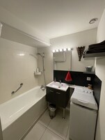 Bañera con ducha, secador de pelo, toallas, shampoo