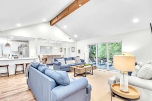 A spacious living area with a sofa, coffee table, and a lamp.