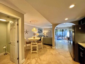 A modern kitchen with a dining area, a large window, and a built-in refrigerator.