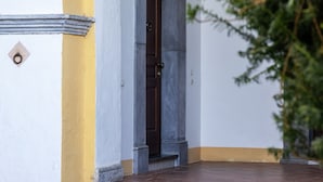 A doorway with a dark door, a yellow and white wall, and a tiled floor. - SMALL COURT MAISON (Piano di Sorrento)