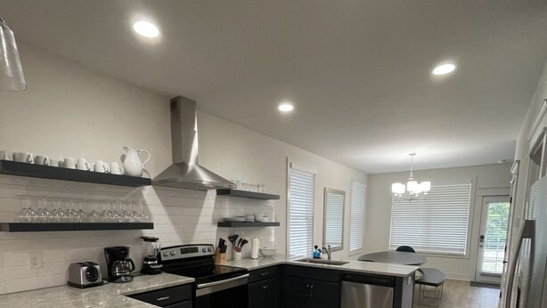 A modern kitchen with granite countertops, stainless steel appliances, and a central island.