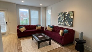 A living room with two red sofas, a coffee table, and a rug.