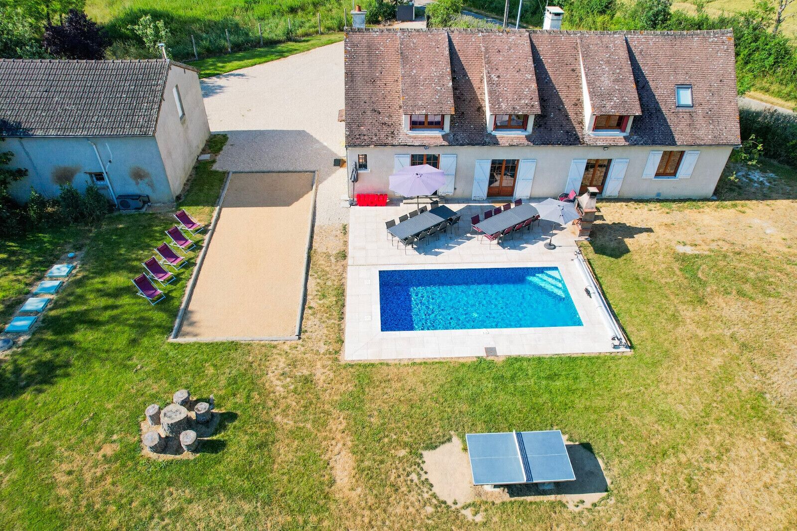 Propiedad residencial con piscina, mobiliario exterior y panel solar.
