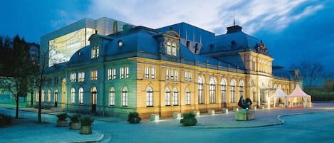 A large, historic building with a prominent dome and a modern glass extension.