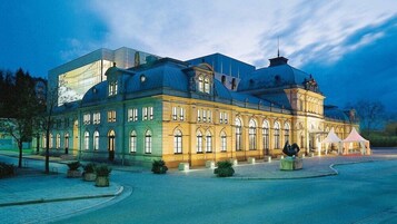 Un edificio grande e histórico, con una cúpula destacada y un moderno añadido de cristal.