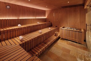 A sauna with wooden benches and a wooden bench with a towel holder. - Hotel-restaurant Erbprinz (Ettlingen)